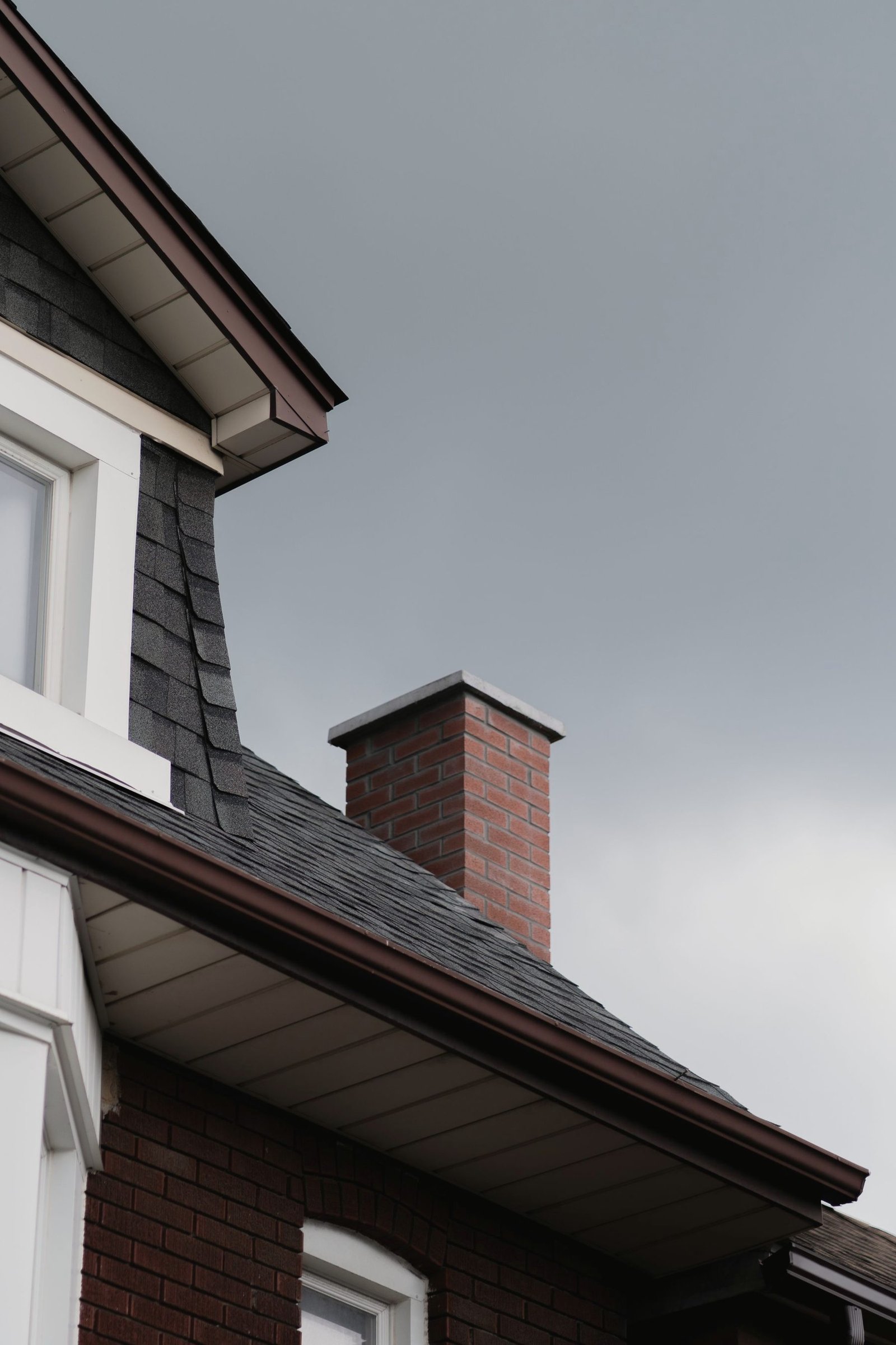 A brick chimney rising through a pitched roof.